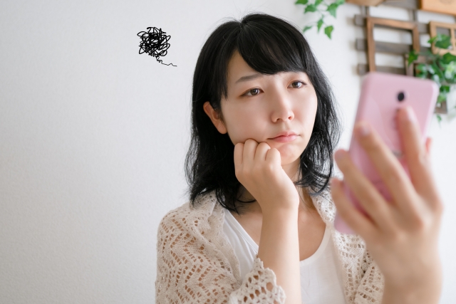 スマホを見ながら困っている年下女性